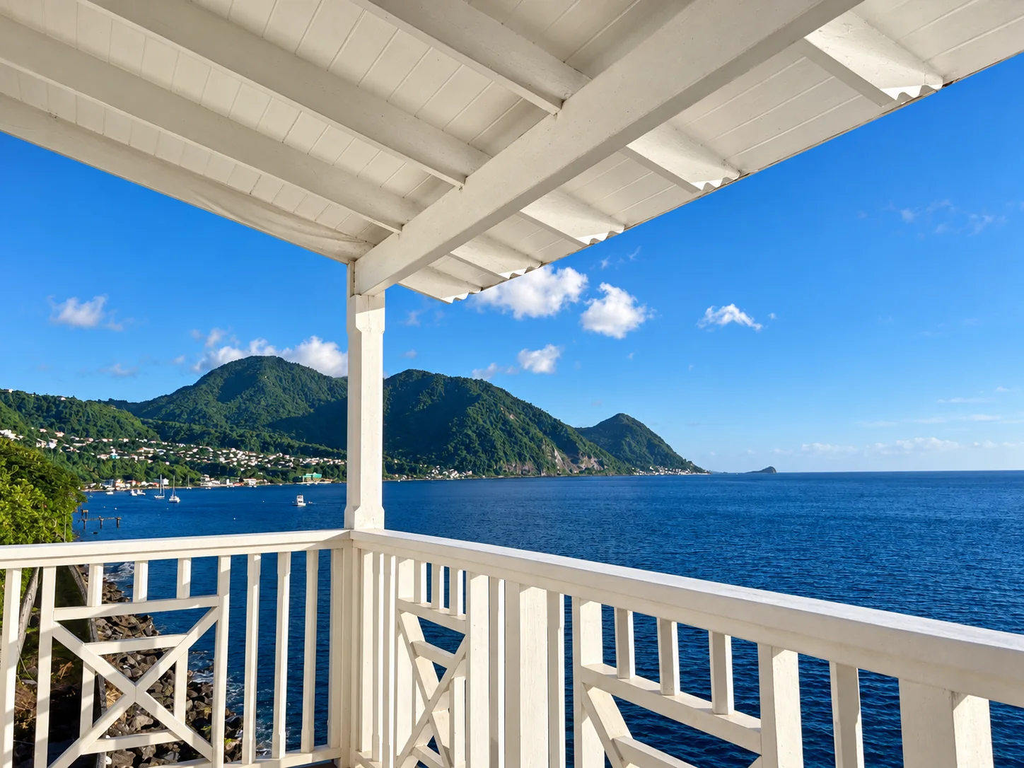A white veranda overlooking the sea and Dominica’s green mountains
