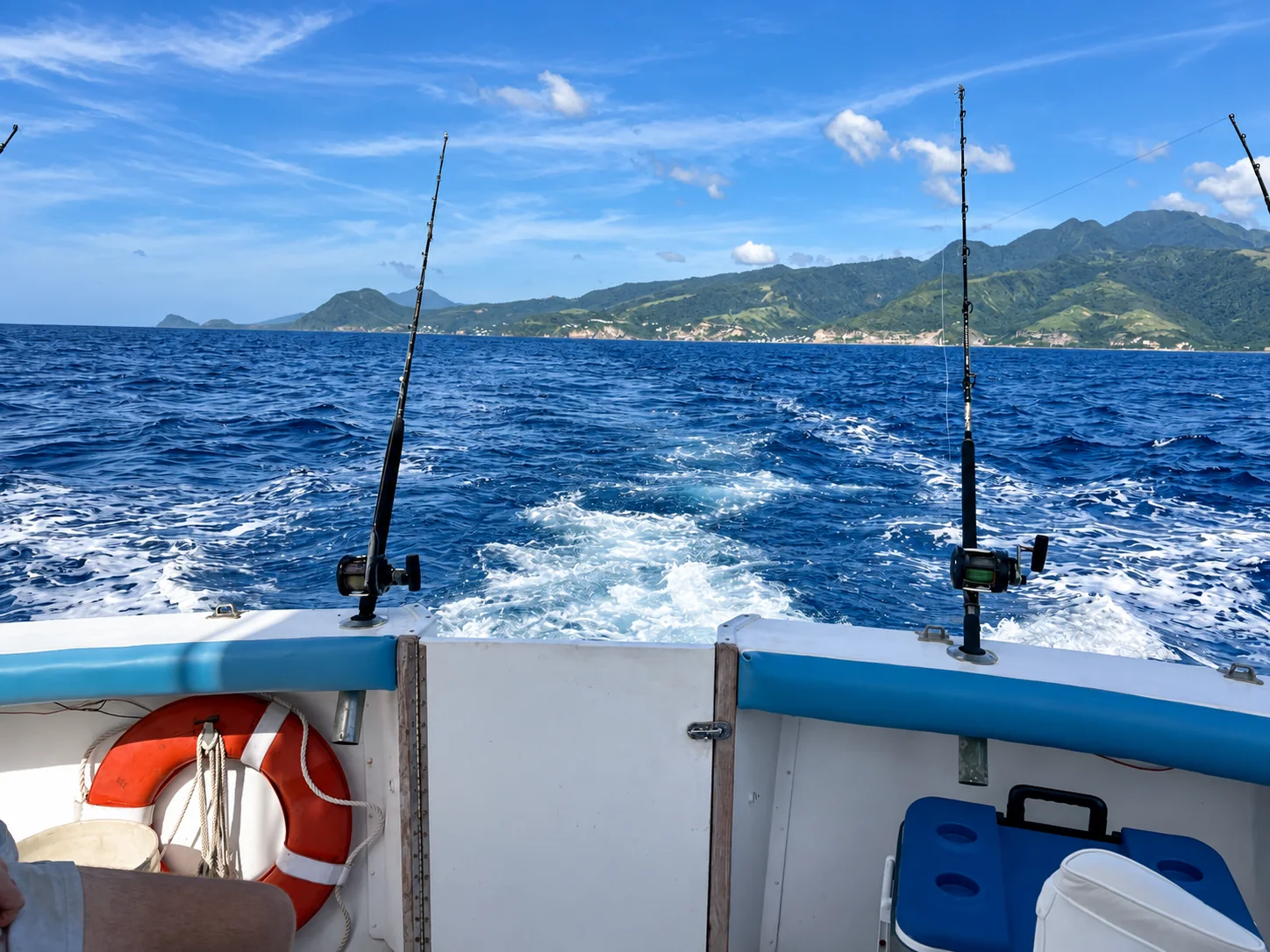 A boat’s wake with Dominica’s mountains in the background